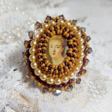 Bague Madame de Pompadour brodée avec un cabochon représentant une femme à laquelle s'ajoute des toupies, perles rondes nacrées, rocailles aux couleurs Jaune et Marron sur bague Bronze en laiton
